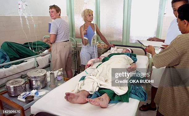 Relatives help take care of victims at Sanglah general hospital in Denpasar, on the Indonesian island of Bali, 13 October 2002, following a car bomb...