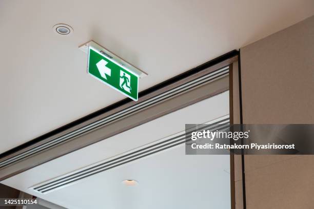 a green warning sign for emergency exit or fire escape inside the building - 非常口 ストックフォトと画像