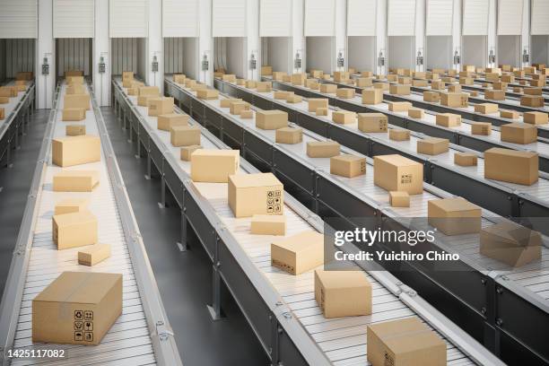 boxes on conveyor belt heading to truck loading dock - distribution warehouse stock-fotos und bilder