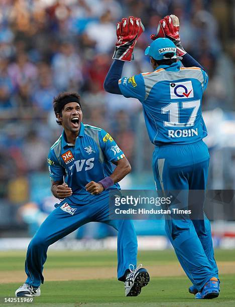 Ashok Dinda of the Pune Warriors celebrates with wicket keeper Robin Uthappa after capturing the wicket of Ambati Rayudu of the Mumbai Indians during...