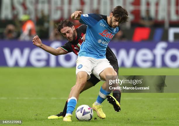 Khvicha Kvaratskhelia of SSC Napoli is challenged by Davide Calabria of AC Milan during the Serie A match between AC Milan and SSC Napoli at Stadio...