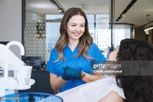 glücklicher zahnarzt mit patient - dentalhygieniker stock-fotos und bilder