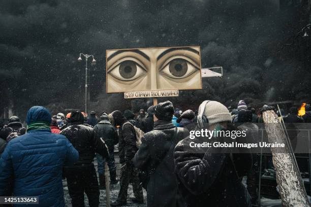 Oleksandr Melnyk, Ukrainian muralist, holds his painting “I see your deeds, human!”, on which the eyes of the Lord are depicted, standing amid...