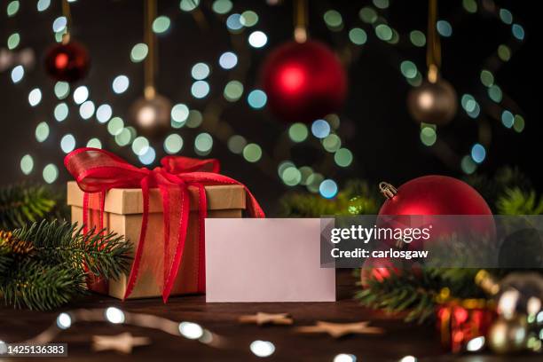 regalo de navidad junto a una tarjeta de felicitación con espacio de copia - christmas still life fotografías e imágenes de stock