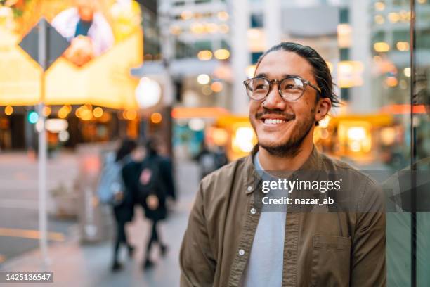 young man with glasses enjoying city. - 毛利人 個照片及圖片檔