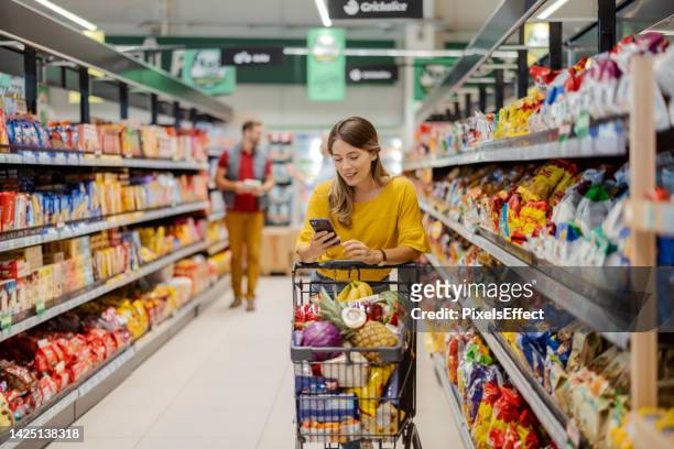 purchasing goods with smartphone at grocery store - serbia supermarket stock pictures, royalty-free photos & images