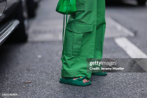 Guest is seen wearing green cargo pants, green Bottega Veneta bag, silver and gold Cartier Love bracelets, gold Cartier Juste un Clou bracelet and...