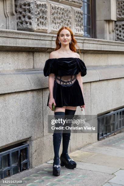 Guest wears black velvet dress outside Simone Rocha during London Fashion Week September 2022 on September 18, 2022 in London, England.