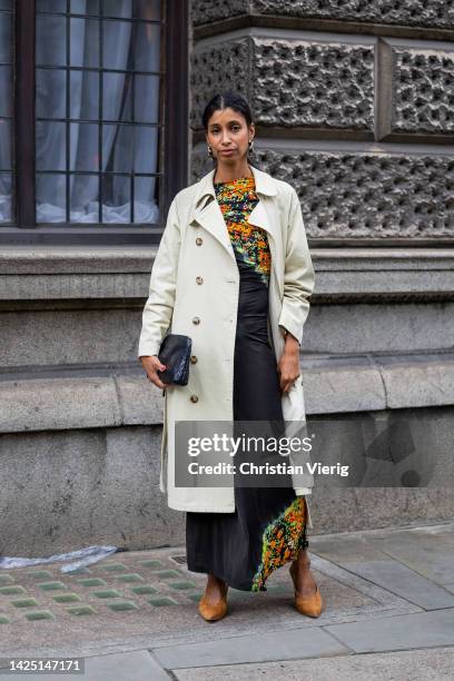 Guest wears black bag, double breasted trench coat outside Simone Rocha during London Fashion Week September 2022 on September 18, 2022 in London,...