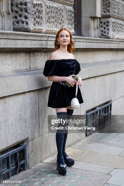 Guest wears black velvet dress outside Simone Rocha during London Fashion Week September 2022 on September 18, 2022 in London, England.