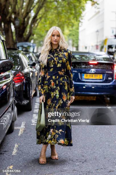 Victoria Magrath wearing floral dress, green bag, heels outside Erdem during London Fashion Week September 2022 on September 18, 2022 in London,...