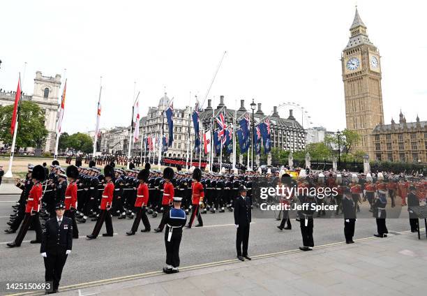 The coffin of Queen Elizabeth II with the Imperial State Crown resting on top, borne on the State Gun Carriage of the Royal Navy proceeds towards...