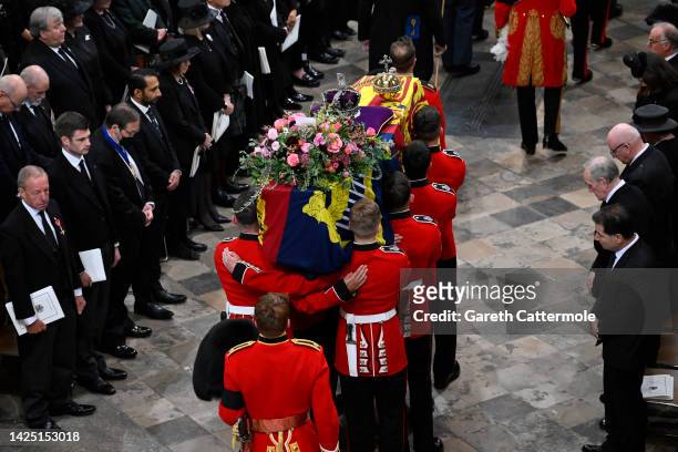 The coffin of Queen Elizabeth II with the Imperial State Crown resting on top is carried by the Bearer Party into Westminster Abbey during the State...