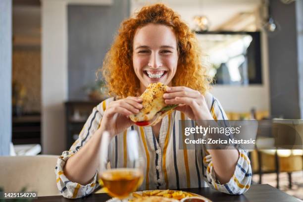 redhead eating a sall sandwich - eating bread stockfoto's en -beelden