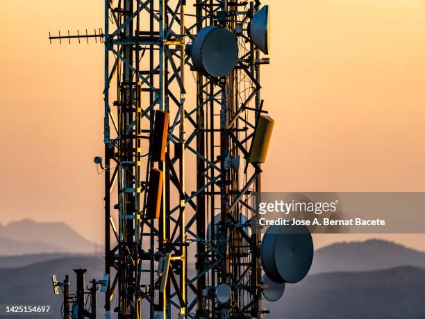 signal receiving communication tower equipment on top of a mountain at sunset. - telecom tower stock pictures, royalty-free photos & images