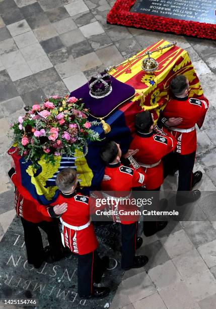 The coffin of Queen Elizabeth II with the Imperial State Crown resting on top is carried by the Bearer Party into Westminster Abbey during the State...