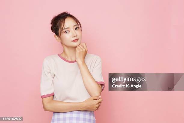 Portrait of young Asian woman in sporty fashion on pink background