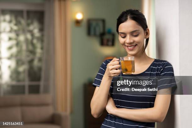 giovane donna che beve tè verde, foto di repertorio - tisana foto e immagini stock