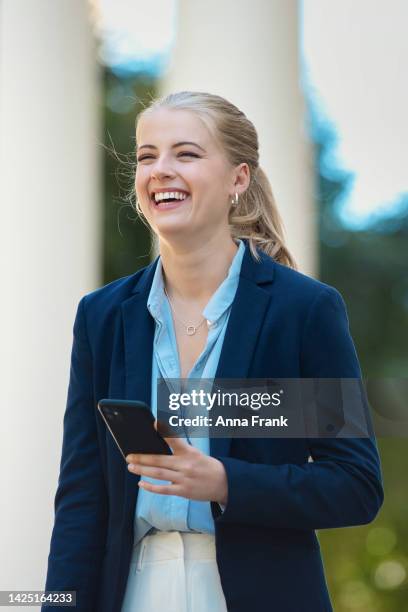 a young business woman laughing in the city - blonde hair woman stock pictures, royalty-free photos & images