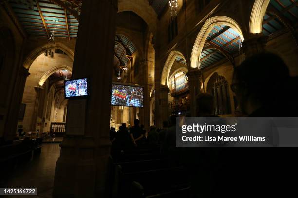 Members of the public view the televised funeral of Queen Elizabeth II at St. Andrew's Cathedral on September 19, 2022 in Sydney, Australia. Queen...