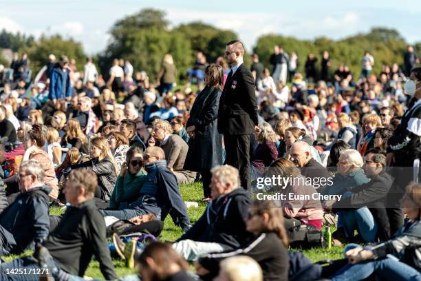 Members of the public watch Queen Elizabeth II's state funeral on a tv screen in Holyrood park on September 19, 2022 in Edinburgh, United Kingdom....