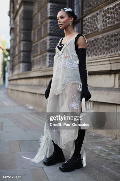 Guest is seen wearing an Ecru Lace Dress, at Simone Rocha during London Fashion Week September 2022 on September 18, 2022 in London, England.