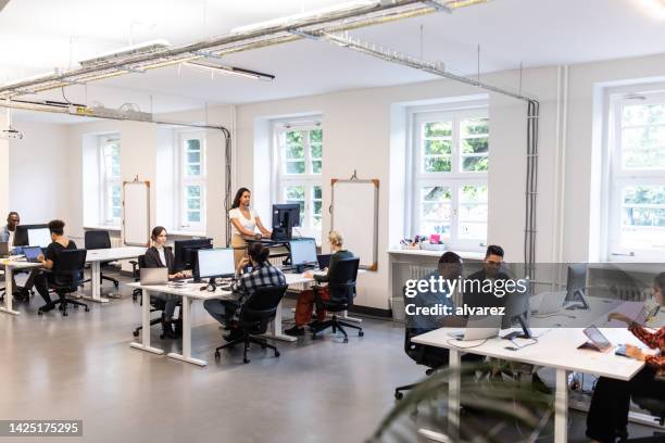 casual elegante lavoratori in una trafficata ufficio open space - ufficio open space foto e immagini stock