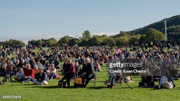 Members of the public watch Queen Elizabeth II's state funeral on a tv screen in Holyrood park on September 19, 2022 in Edinburgh, United Kingdom....
