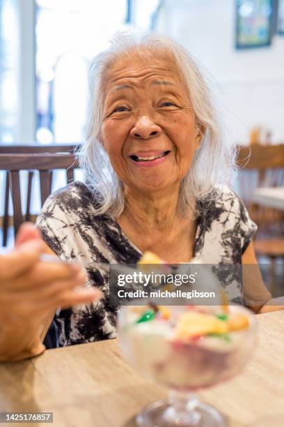 elder woman eating ice cream - seniors ice cream sundae stock pictures, royalty-free photos & images