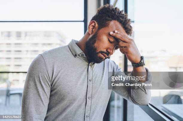 headache, stress and anxiety with a business man suffering from the pressure of deadlines in his office at work. mental health, compliance and burnout with a young male holding his head in pain - system failure stock pictures, royalty-free photos & images