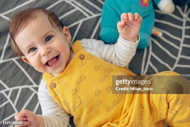 baby lying on bed smiling - moments daily life from above imagens e fotografias de stock