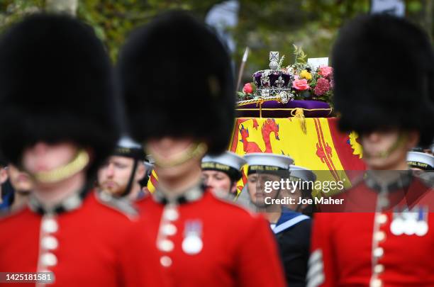 The coffin of Queen Elizabeth II with the Imperial State Crown resting on top is carried by the Bearer Party as it departs Westminster Abbey during...