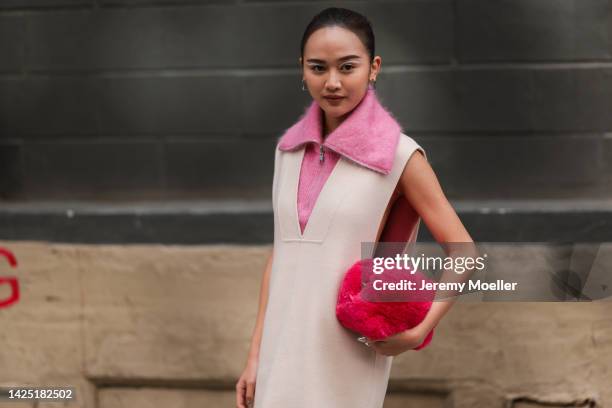 Guest is seen wearing a total COS look and a pink fluffy clutch bag outside COS during New York Fashion Week on September 13, 2022 in New York City.