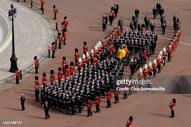 The coffin of Queen Elizabeth II with the Imperial State Crown resting on top, borne on the State Gun Carriage of the Royal Navy followed by members...