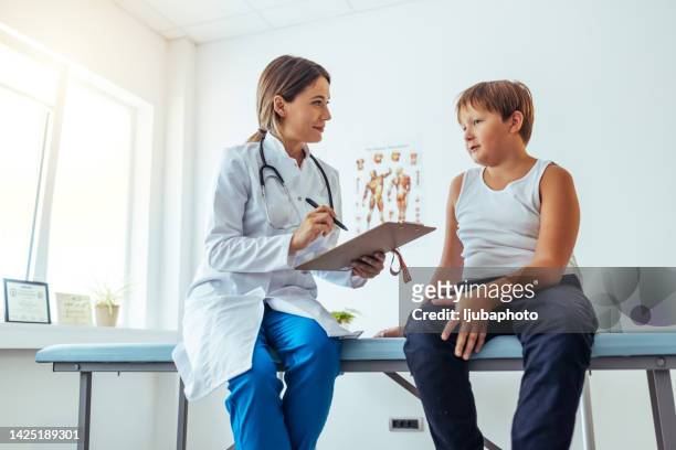 ernährungsberater hält diätplan während der konsultation mit dem patienten im büro - chubby kid stock-fotos und bilder