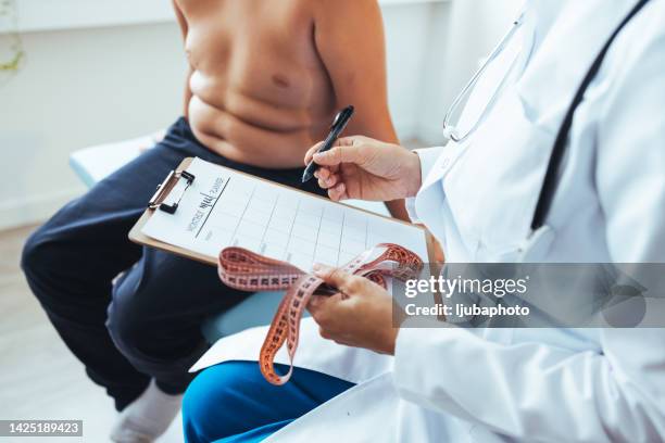 female nutritionist gives consultation to patient indoors in the office - nutritionist stock pictures, royalty-free photos & images