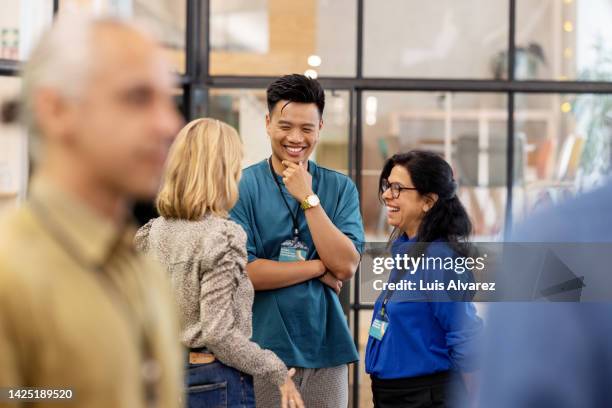 multiracial business people talking before the seminar - ereignis stock-fotos und bilder