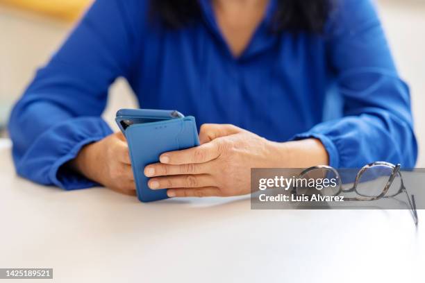 close-up of a businesswoman hands using mobile phone in office - telefon konferenz stock-fotos und bilder