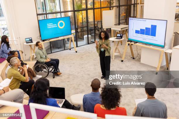 african woman giving presentation to audience at startup conference - working on laptop in train top view stock pictures, royalty-free photos & images