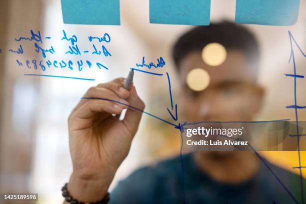 business man drawing statistics on glass board - executive board meeting photos et images de collection