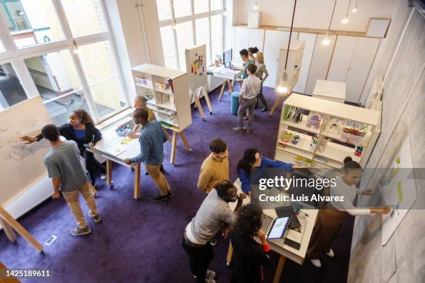 team building activities of small groups at startup office - teambuilding stockfoto's en -beelden