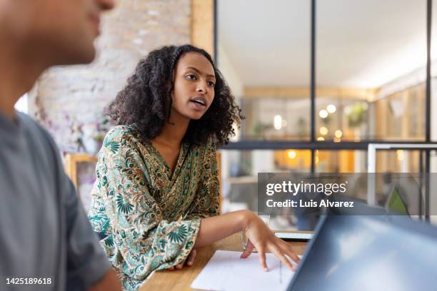 young entrepreneur talking with colleagues in office boardroom - réunion du personnel photos et images de collection