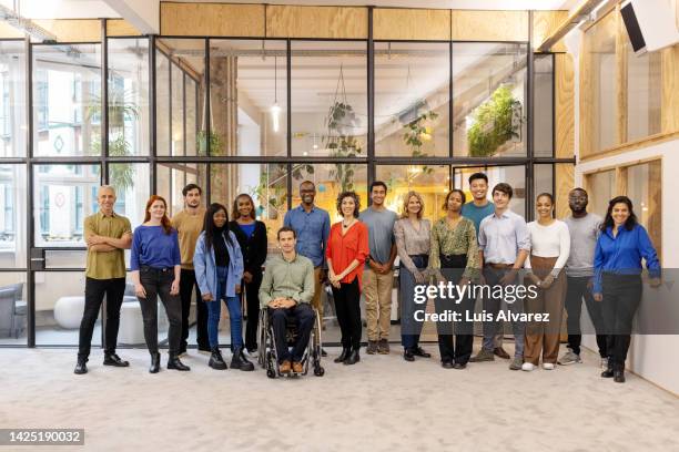 portrait of a multiracial business group standing in office - diversité raciale photos et images de collection