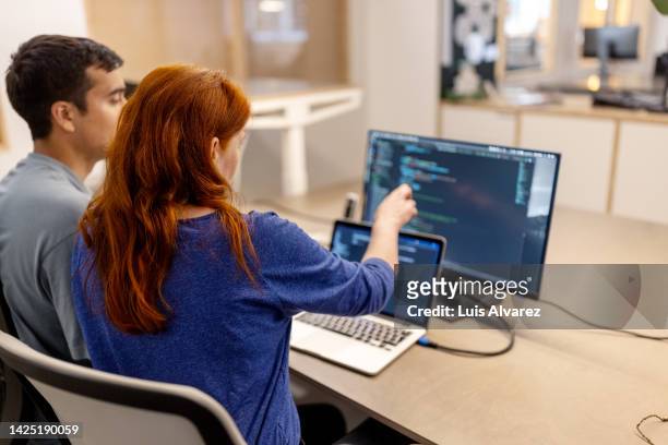 two computer programmers working on a new software development - auburn stock pictures, royalty-free photos & images
