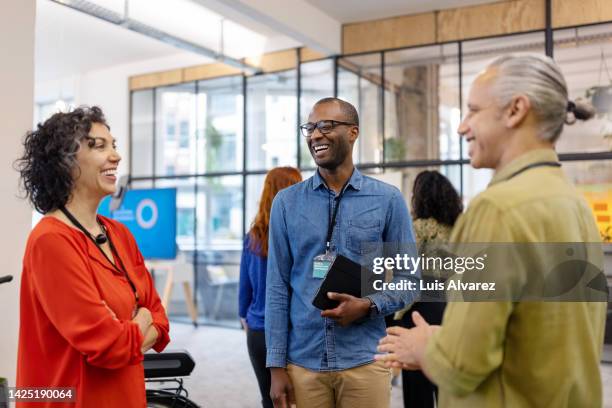 multiracial business people discussing while meeting at launch event - mature business woman digital tablet corporate professional stockfoto's en -beelden