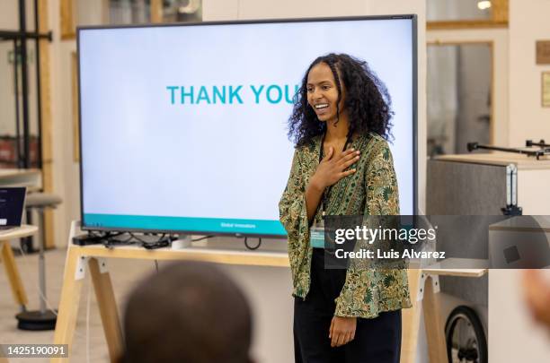 young businesswoman saying thank-you to audience after seminar - gratitude foto e immagini stock