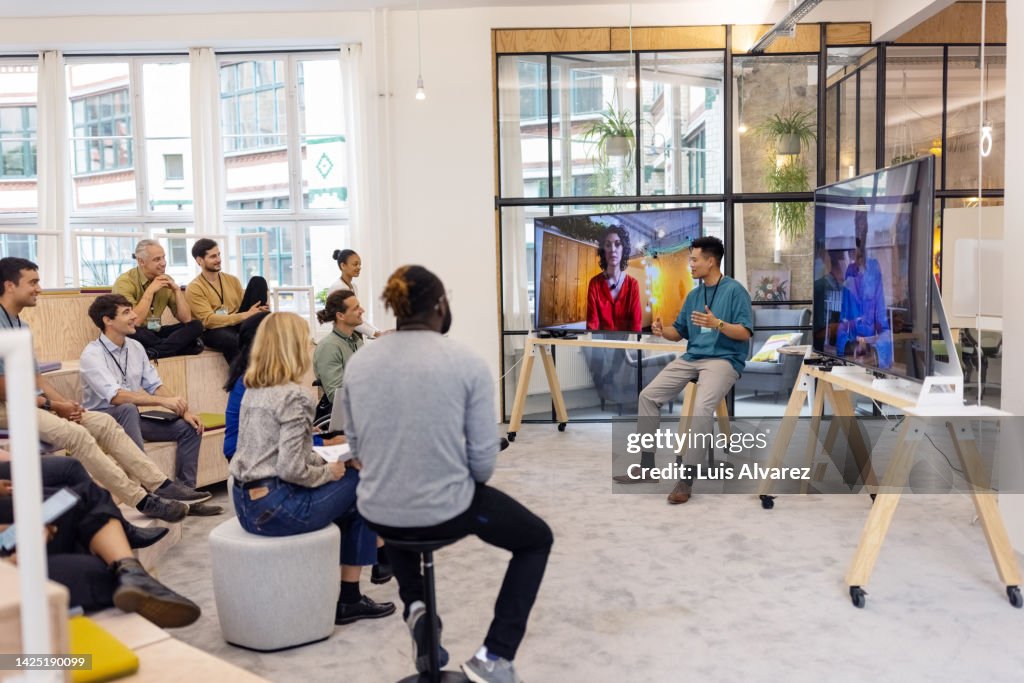 Business people having hybrid meeting in office