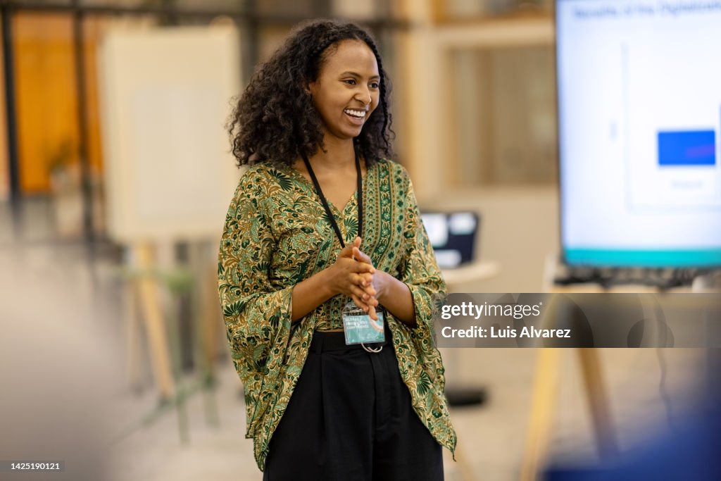 Young woman addressing audience during launch event