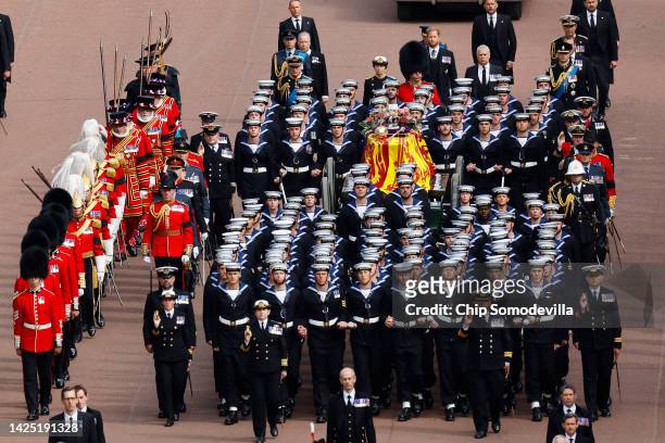 The Queen's funeral cortege borne on the State Gun Carriage of the Royal Navy travels along The Mall with the Gentlemen at Arms on September 19, 2022...