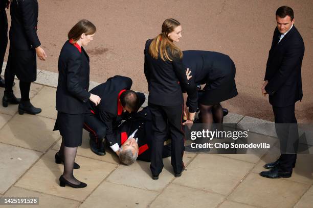 Buckingham Palace household staff person collapses outside Buckingham Palace after paying their respects during the State Funeral of Queen Elizabeth...